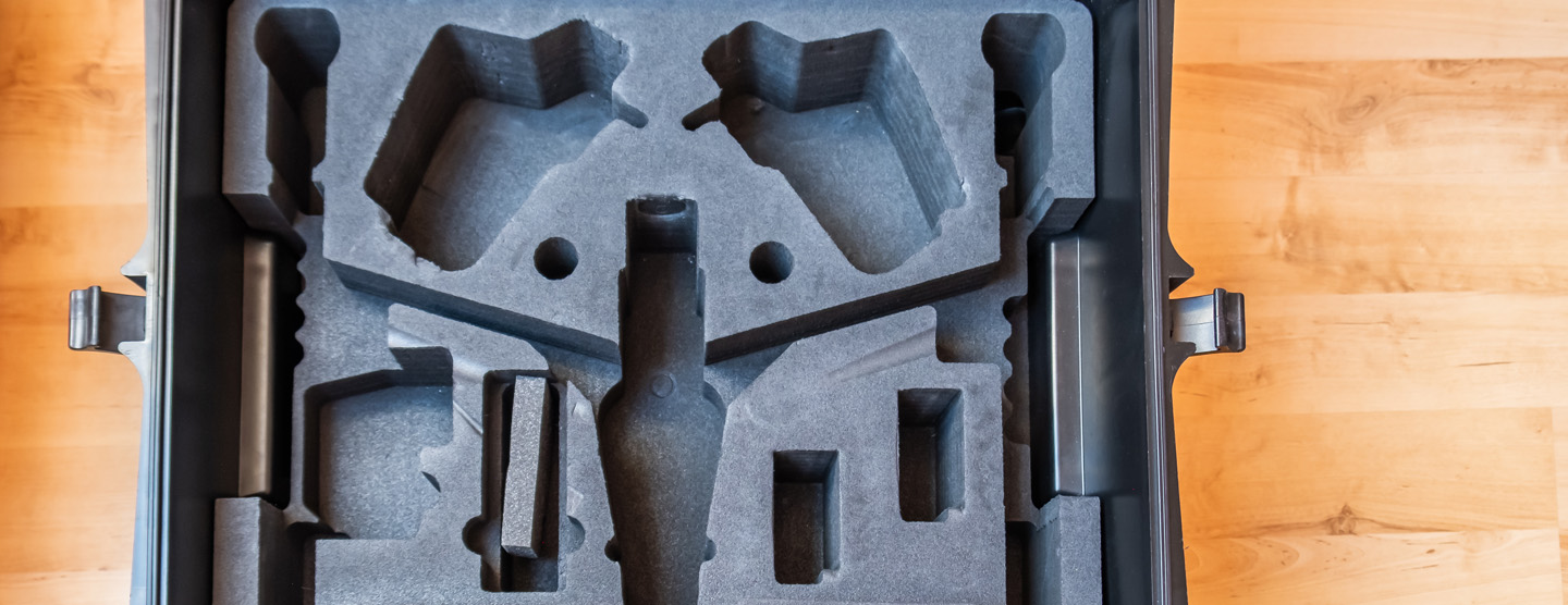 cut to shape foam to fit a drone, inside a black case on a wooden table